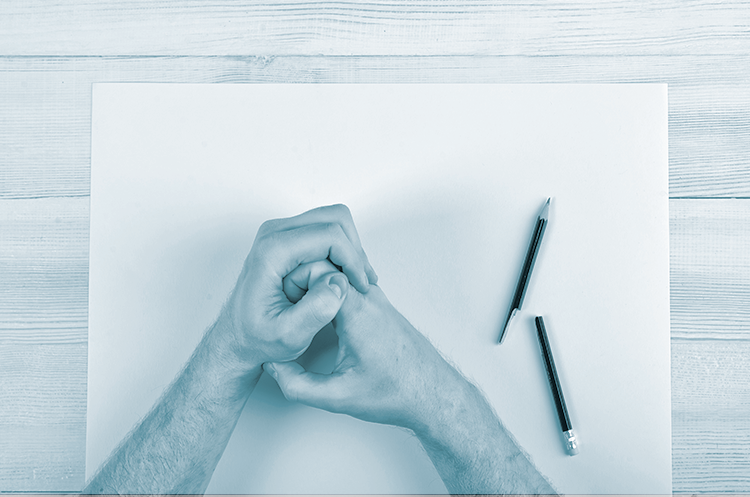 Hænder på et bord med papir og blyant